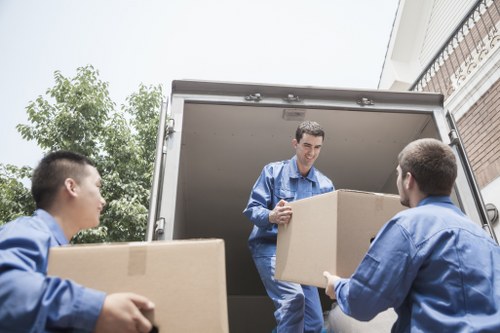 Professional movers handling furniture with a removal van
